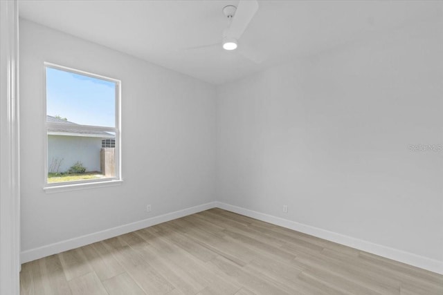 empty room featuring ceiling fan, light wood-style flooring, and baseboards