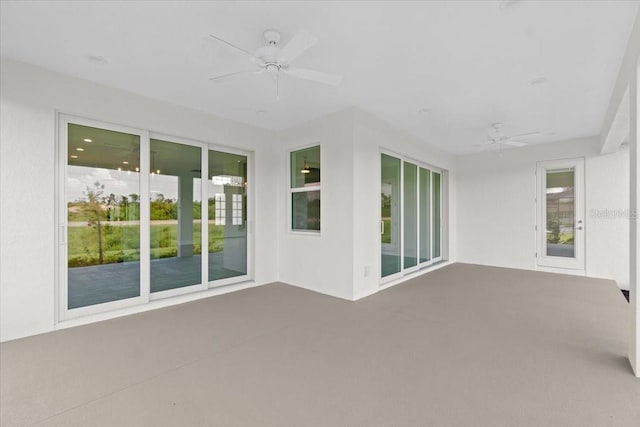 unfurnished sunroom with a ceiling fan