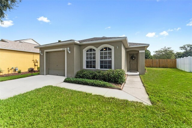 view of front of home with a garage and a front lawn