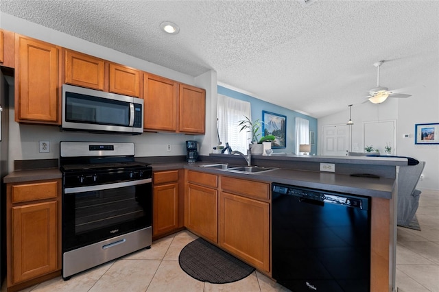 kitchen with sink, kitchen peninsula, lofted ceiling, light tile patterned floors, and appliances with stainless steel finishes