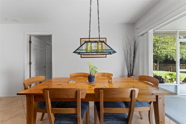 dining room with light tile patterned floors and a textured ceiling