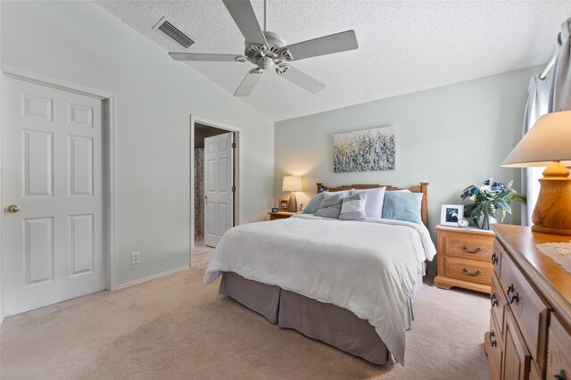 bedroom with light carpet, a textured ceiling, ceiling fan, and lofted ceiling