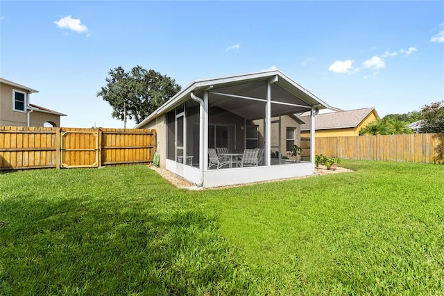 back of house with a lawn, a fenced backyard, and a sunroom