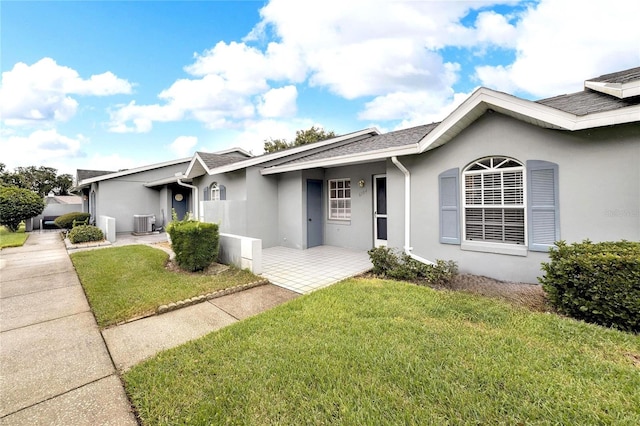 single story home featuring central AC unit and a front lawn