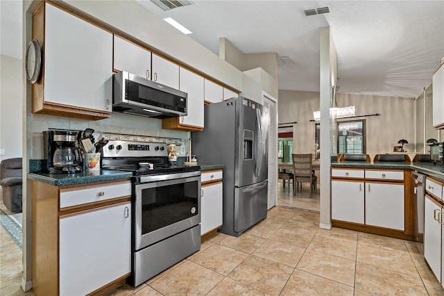 kitchen featuring light tile patterned floors, white cabinetry, stainless steel appliances, and tasteful backsplash