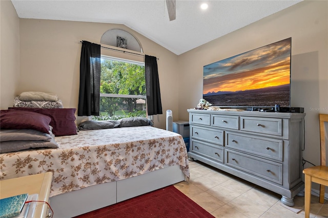 bedroom with lofted ceiling, ceiling fan, and light tile patterned flooring