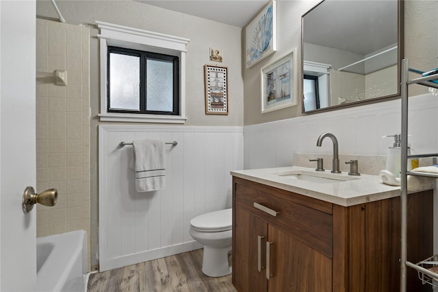 full bathroom featuring vanity, toilet, tiled shower / bath combo, and hardwood / wood-style floors