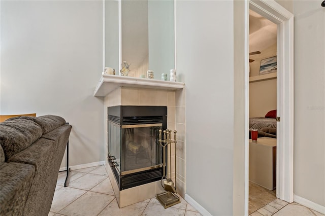 living room featuring a tile fireplace and light tile patterned flooring