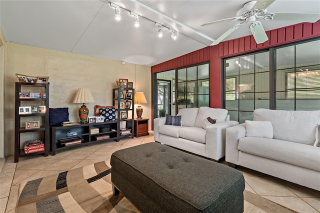 tiled living room featuring rail lighting, ceiling fan, and vaulted ceiling