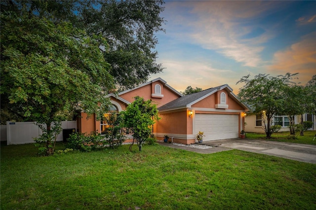 view of front of home with a garage and a lawn