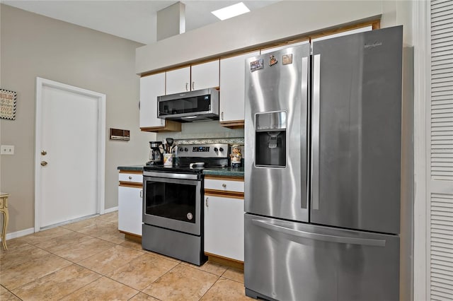 kitchen with light tile patterned floors, stainless steel appliances, and white cabinets