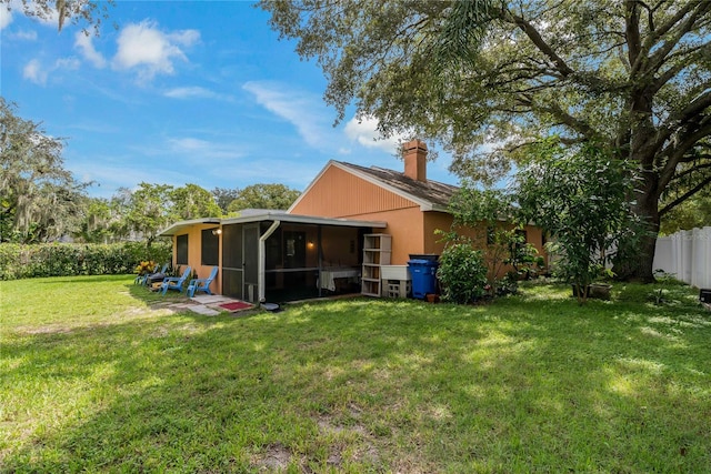 back of property featuring a lawn and a sunroom