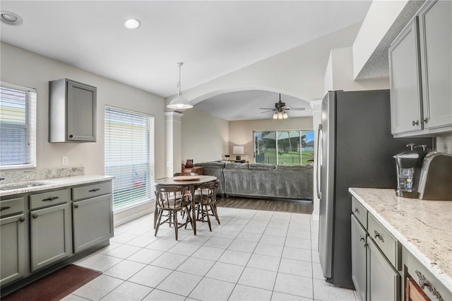 kitchen with gray cabinetry, light hardwood / wood-style flooring, decorative light fixtures, stainless steel refrigerator, and ceiling fan