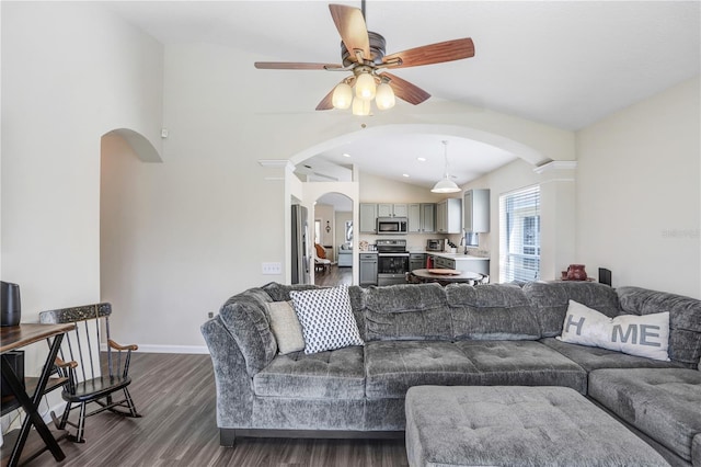 living room with dark wood-type flooring, ceiling fan, and vaulted ceiling