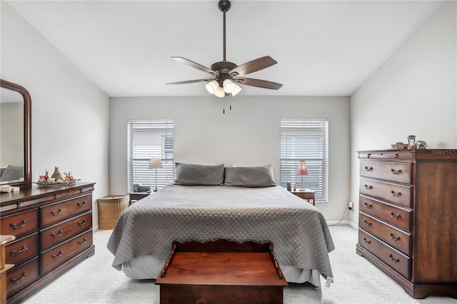 bedroom featuring multiple windows, ceiling fan, and light colored carpet