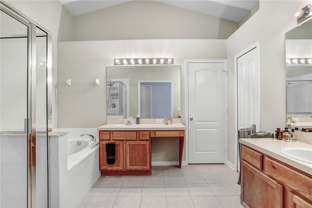 bathroom with tile patterned floors, vanity, separate shower and tub, and vaulted ceiling