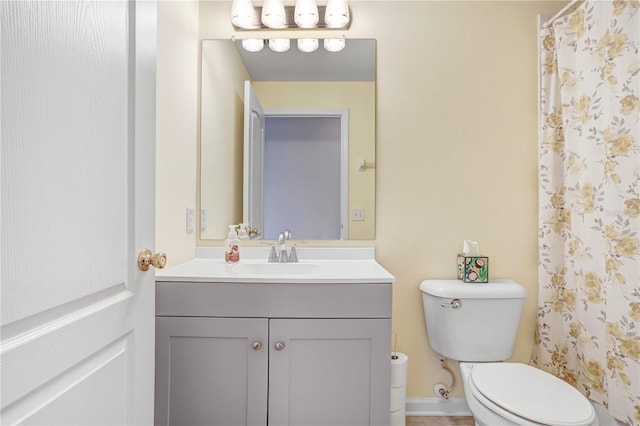 bathroom featuring vanity, toilet, and curtained shower