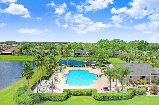 view of pool featuring a patio area, a yard, and a water view