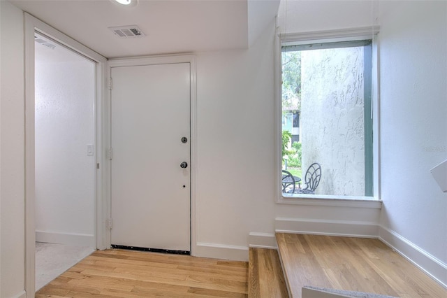 entryway featuring light wood-style floors, baseboards, and visible vents