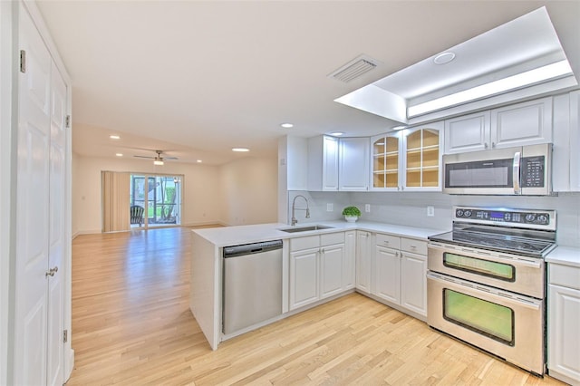 kitchen featuring stainless steel appliances, white cabinetry, and light hardwood / wood-style floors