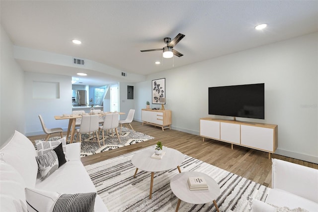 living room featuring ceiling fan and light hardwood / wood-style floors