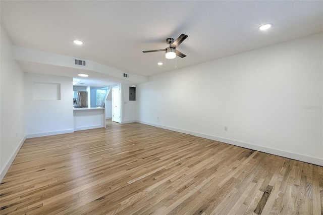 unfurnished living room with a textured ceiling, light hardwood / wood-style flooring, and ceiling fan