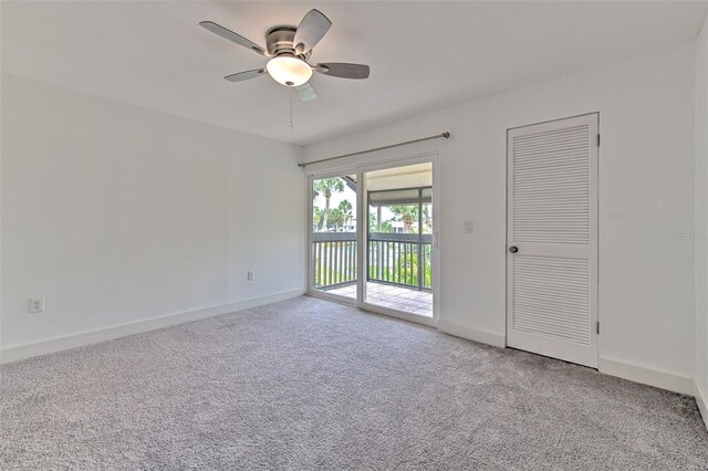 carpeted spare room featuring ceiling fan