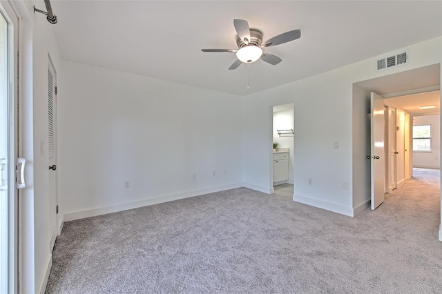 unfurnished bedroom with light carpet, ensuite bath, and ceiling fan