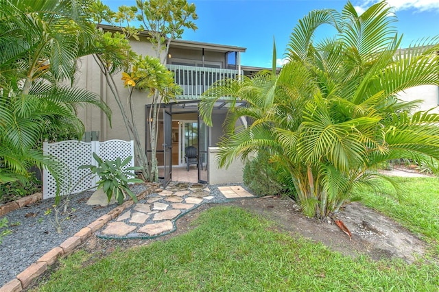 exterior space featuring a front lawn and a balcony