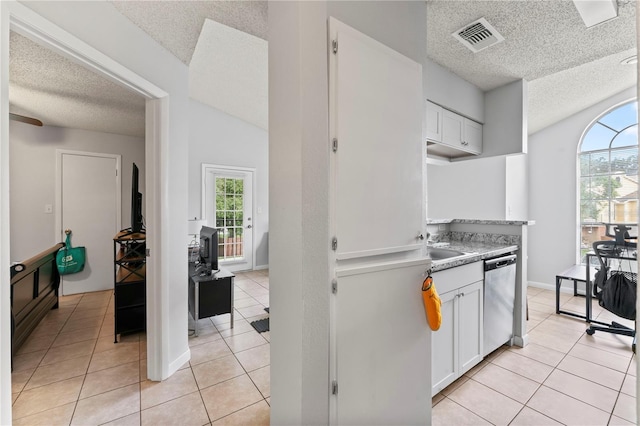 kitchen with visible vents, white cabinets, light tile patterned flooring, a textured ceiling, and dishwasher