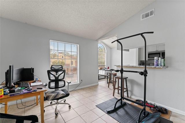 office area with light tile patterned floors, lofted ceiling, visible vents, a textured ceiling, and baseboards