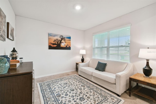 carpeted living area with baseboards