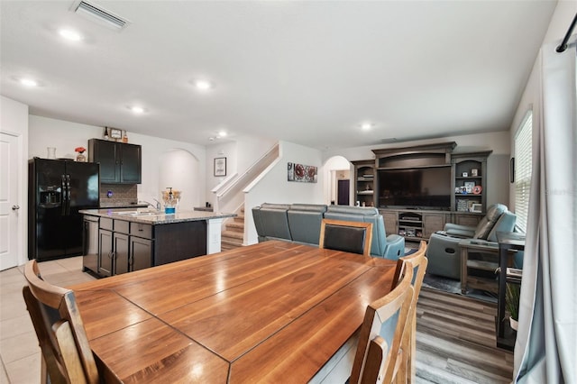 dining space with visible vents, recessed lighting, arched walkways, stairs, and light wood-type flooring