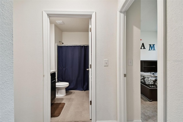 bathroom featuring toilet, vanity, walk in shower, and tile patterned floors