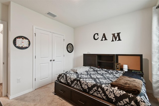 bedroom featuring a closet, visible vents, light colored carpet, and baseboards