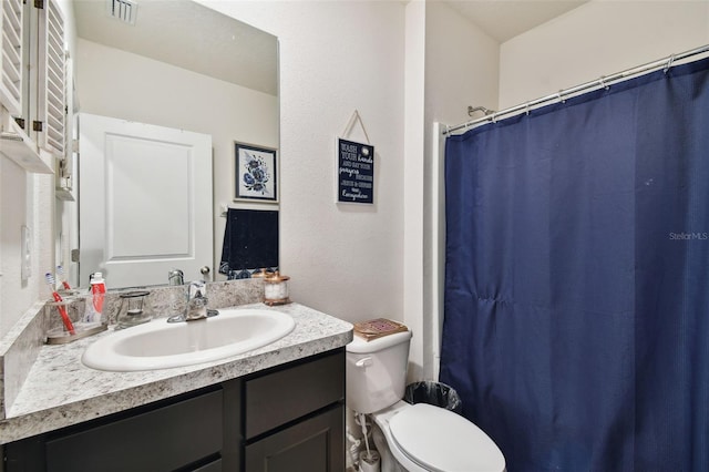 bathroom featuring visible vents, toilet, vanity, and a shower with curtain