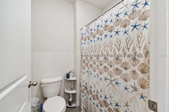 bathroom featuring tile patterned floors, walk in shower, and toilet