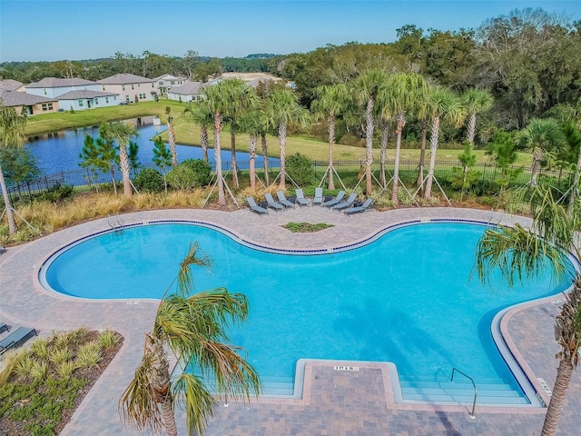 community pool with fence and a water view