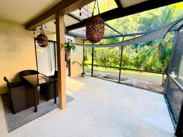 unfurnished sunroom with beam ceiling and a healthy amount of sunlight