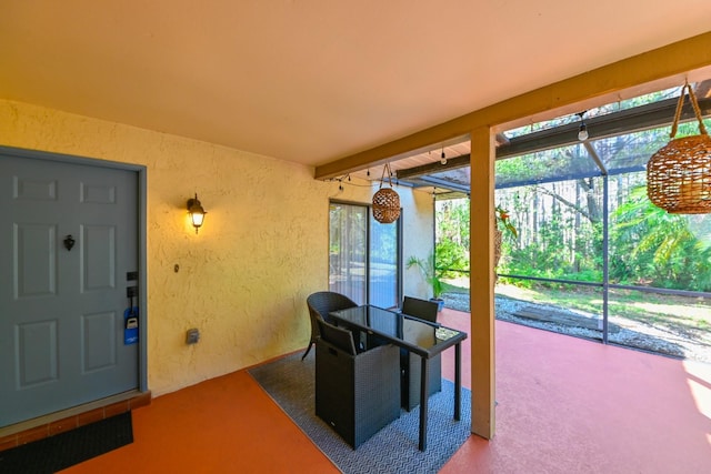 sunroom / solarium featuring beam ceiling