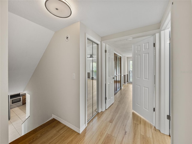 corridor with heating unit and light hardwood / wood-style flooring