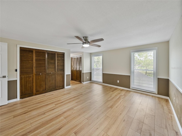 unfurnished bedroom with ceiling fan and light hardwood / wood-style floors