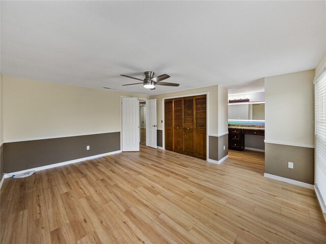 unfurnished bedroom featuring light wood-type flooring, built in desk, and ceiling fan