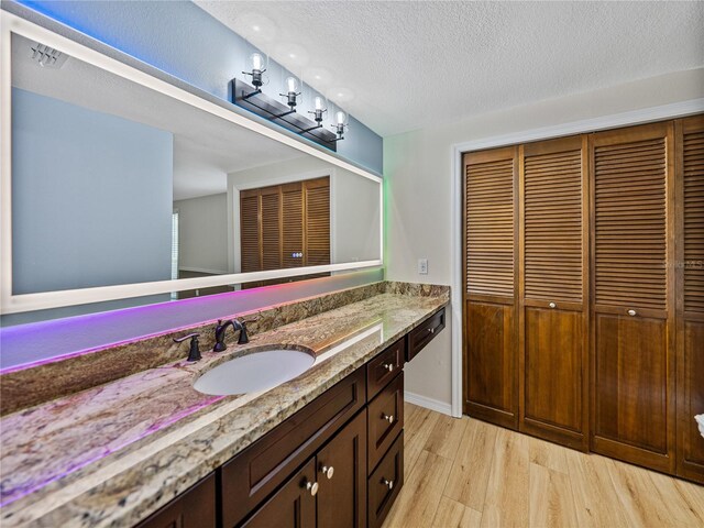 bathroom featuring hardwood / wood-style flooring, a textured ceiling, and vanity