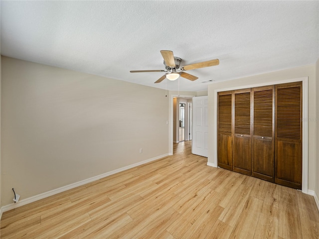 unfurnished bedroom with ceiling fan, a closet, and light hardwood / wood-style floors