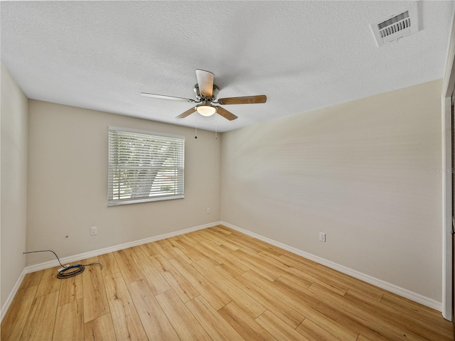 empty room featuring a textured ceiling, ceiling fan, and light wood-type flooring