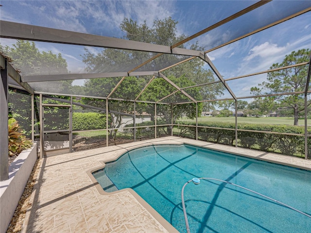 view of swimming pool featuring a lanai and a patio area