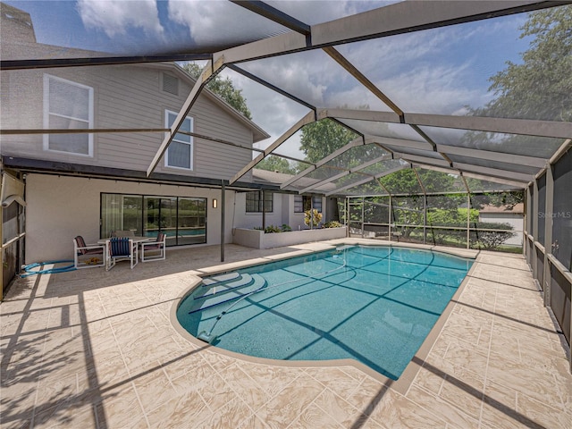 view of swimming pool featuring glass enclosure and a patio area