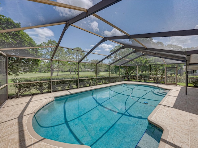 view of swimming pool featuring a lanai and a patio area