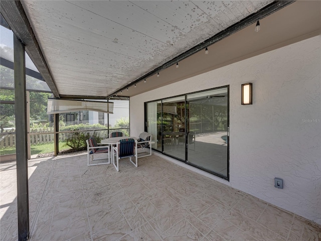 unfurnished sunroom with track lighting